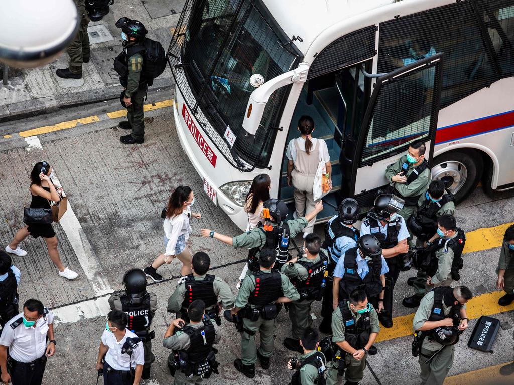 Women are arrested and led onto a bus by police during a protest against China’s planned national security law in Hong Kong on June 28. Picture: Isaac Lawrence/AFP