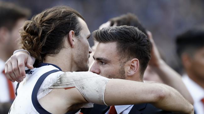 Phil Davis consoles injured midfielder Stephen Coniglio post-match. Picture: Ryan Pierse/AFL Media/via Getty Images.