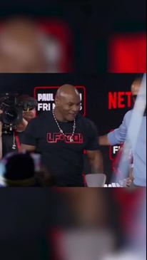 Mike Tyson giggles as he pushed back by Jake Paul