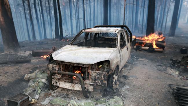 A burnt out car sits surrounded by remnants of a forest. Picture: Gary Ramage