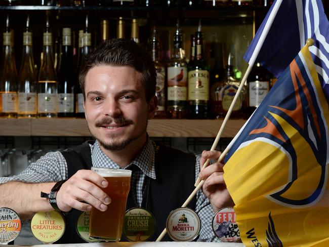 Big business: Subiaco Hotel barman Vedran Yaksich raises a glass to football. Picture: Daniel Wilkins