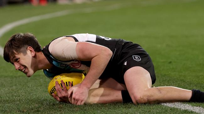 Zak Butters clutches his knee after injurying himself against the Demons at Adelaide Oval. Picture: AFL Photos via Getty Images