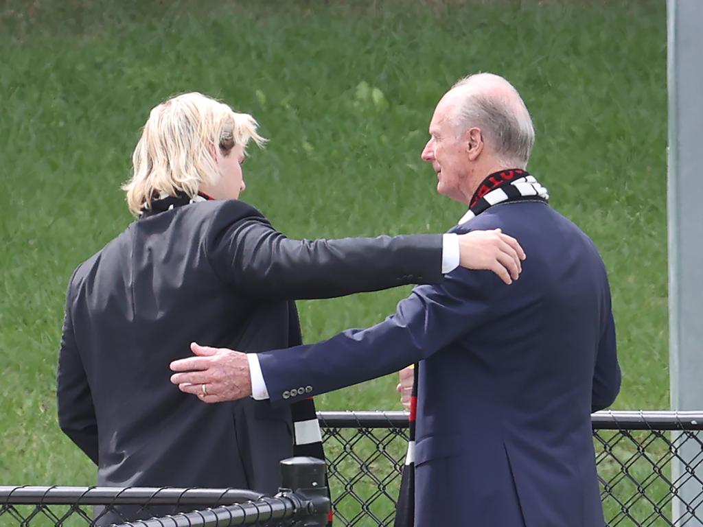 Jackson Warne hugs his grandfather Keith Warne after watching the hearse leave the ground. Picture: David Caird