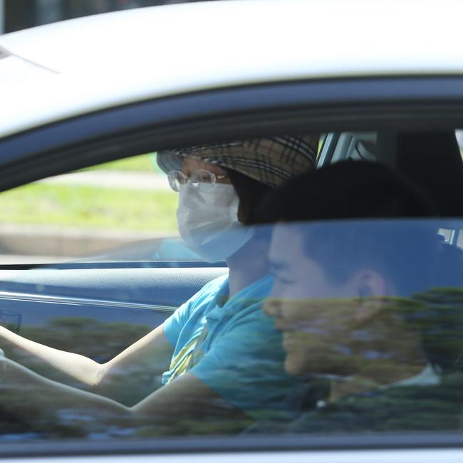 6/3/20: A mother fits out her boys in masks and gloves on their arrival from an Epping Boys High school camp. The school is closed because one of its students has tested positive to the coronavirus. John Feder/The Australian