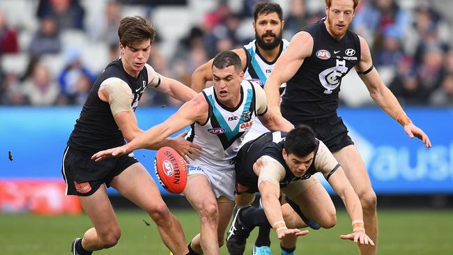 Tom Rockliff heaps on the pressure against Carlton’s Matthew Kennedy and Patrick Dow last week. Picture: Quinn Rooney/Getty Images