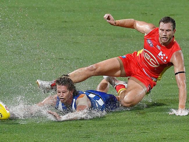 CAIRNS, AUSTRALIA - MARCH 24:  Jed Anderson of the Kangaroos is tackled by Sam Day of the Suns during the round one AFL match between the Gold Coast Suns and the North Melbourne Kangaroos at Cazaly's Stadium on March 24, 2018 in Cairns, Australia.  (Photo by Ian Hitchcock/Getty Images)