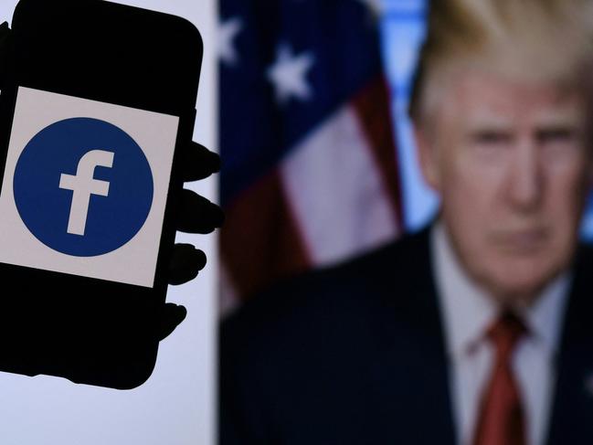 In this photo illustration, a phone screen displays a Facebook logo with the official portrait of former US President Donald Trump on the background, on May 4, 2021, in Arlington, Virginia. - Facebook's independent oversight board was set for a momentous decision on the platform's ban of former US president Donald Trump, as debate swirls on the role of social media in curbing hateful and abusive speech while controlling political discourse. (Photo by Olivier DOULIERY / AFP)