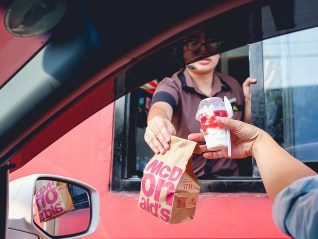 Bangkok, Thailand - Mar 4, 2017: Unidentified customer receiving hamburger and ice cream after order and buy it from McDonald's drive thru service, McDonald's is an American fast food restaurant chain