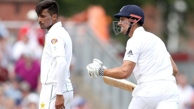 England's Alastair Cook celebrates his century next to Pakistan’s Mohammad Amir.