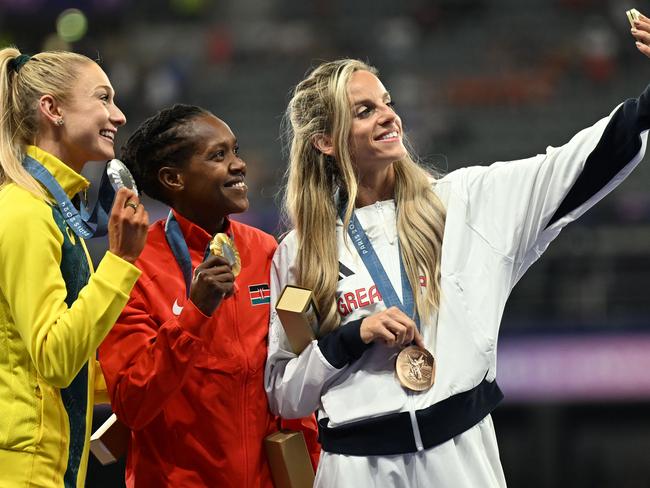 The three medallists – Jessica Hull, gold medallist Kenya's Faith Kipyegon and bronze medallist Britain's Georgia Bell take a selfie as they celebrate on the podium. Picture: Martin Bernetti/ AFP