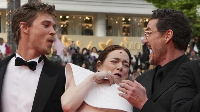 Emma Stone avoids a bee while with Austin Butler, left, and Pedro Pascal. Picture: AP Photo/Natacha Pisarenko