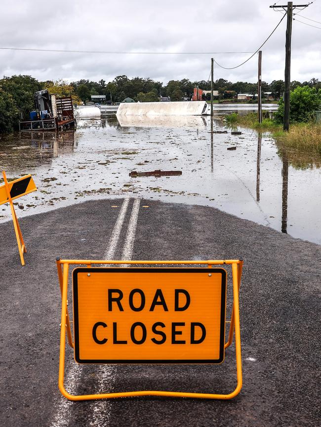 A road closure sign is displayed in front of a truck that was pushed onto its side by floodwaters on March 23, 2021 in the western Sydney suburb of McGraths Hill. Picture: David Gray/Getty Images