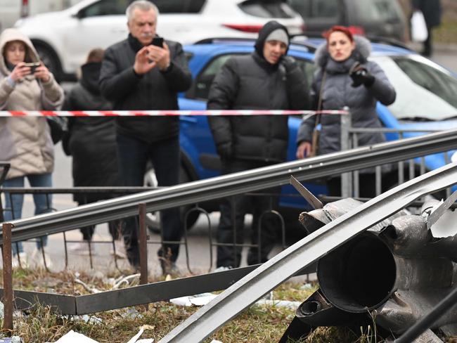 People standing around the remains of a shell in Kyiv. Picture: Sergei Supinsky/AFP