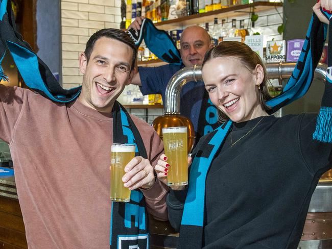 Port  fans Joseph Vella and Adele Spark cheer on the Power at the Archer Hotel in North Adelaide served by barman Karl Cornel.Wednesday,September,4,2024.Picture Mark Brake