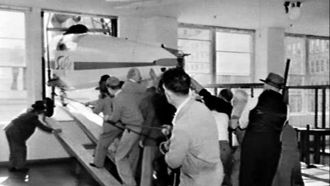 Staff work to place the Swedish Safir light plane through a third floor window at David Jones.