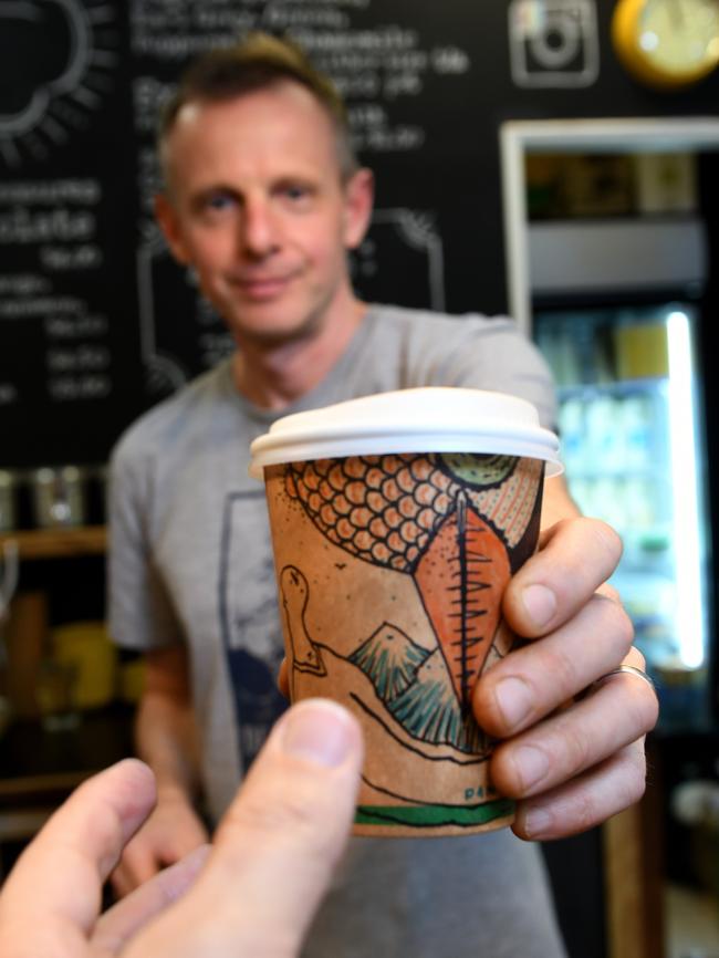 Book Nook &amp; Bean cafe owner Paul Arguile serves a coffee. Picture: AAP/Mark Brake