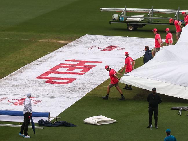 Groundsmen remove covers from over the pitch during a rain delay at the third cricket Test match between Australia and South Africa at the Sydney Cricket Ground (SCG) in Sydney on January 7, 2023. (Photo by DAVID GRAY / AFP) / -- IMAGE RESTRICTED TO EDITORIAL USE - STRICTLY NO COMMERCIAL USE --