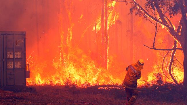 Bushfire near Coningham, a firefighter struggles to contain the blaze on a threatened property