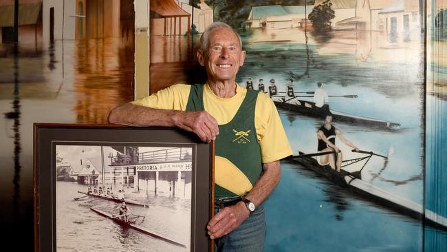 John Banks, pictured in front of a mural, showing him rowing down the main street of Mannum during the flood, and with the original photo. Photo Naomi Jellicoe