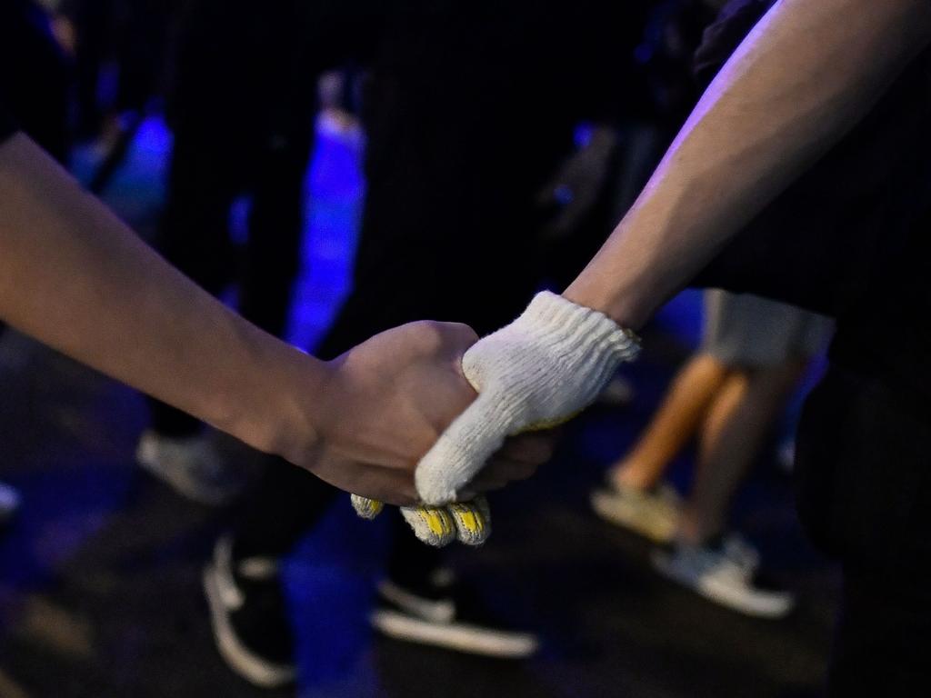 Protesters hold hands as they retreat from a police advance during a demonstration in Hong Kong. Picture: AFP