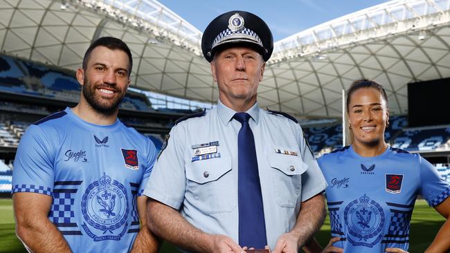 DAILY TELEGRAPH AUGUST 27, 2024. Roosters captains James Tedesco and Isabelle Kelly with NSW Police Assistant Commissioner Gavin Wood with the Commissioner medal that will be awarded to the player of the match at Allianz Stadium ahead of their Emergency Services NRL Event this weekend. Picture: Jonathan Ng