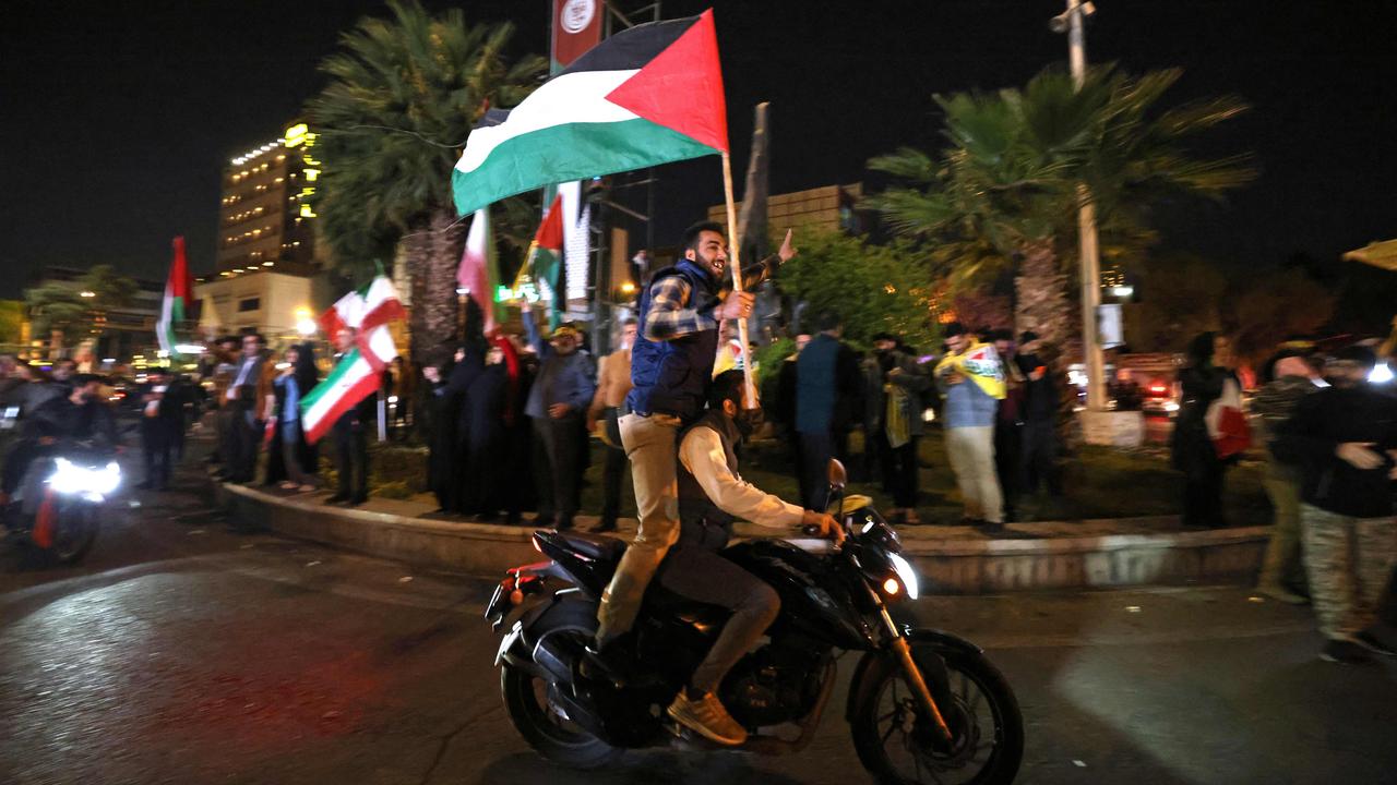 Demonstrators wave Iran's flag and Palestinian flags as they gather at Palestine Square in Tehran on April 14, after Iran launched a drone and missile attack on Israel. Picture: AFP