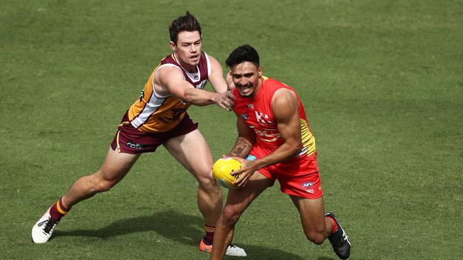 Izak Rankine of the Suns is tackled by Lachie Neale of the Lions. Picture: Getty Images