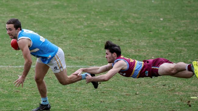 Nicholas Argento, of Monash Blues, breaks free from a lunging Will Campitelli (Marcellin). Picture: George Salpigtidis