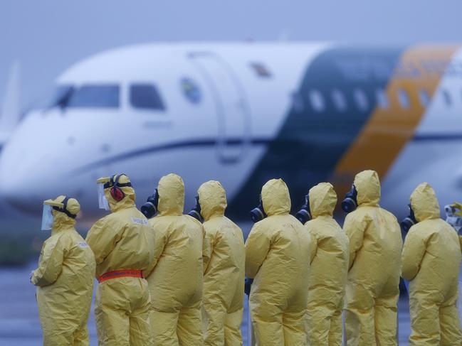 Soldiers wear protective suits during the arrival of Brazilians repatriated from Wuhan, China. Picture: AP