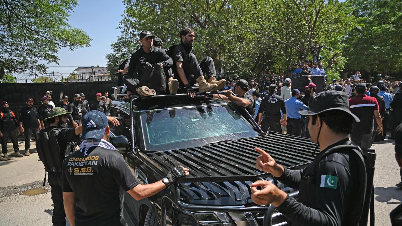 Security personnel escort a car carrying Pakistan's former Prime Minister Imran Khan as he arrives at the high court in Islamabad. (Photo by Aamir QURESHI / AFP)