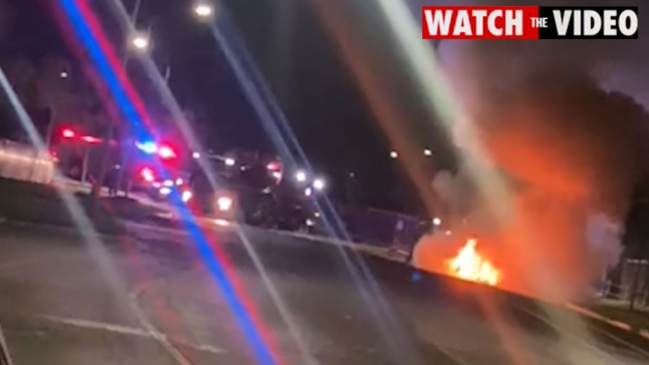 A car is on fire not far from where a man was shot dead in the street