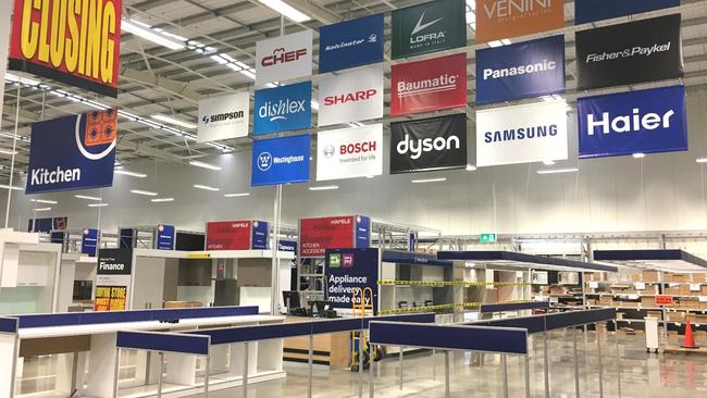 Signage advertising big brands hangs above empty aisles.