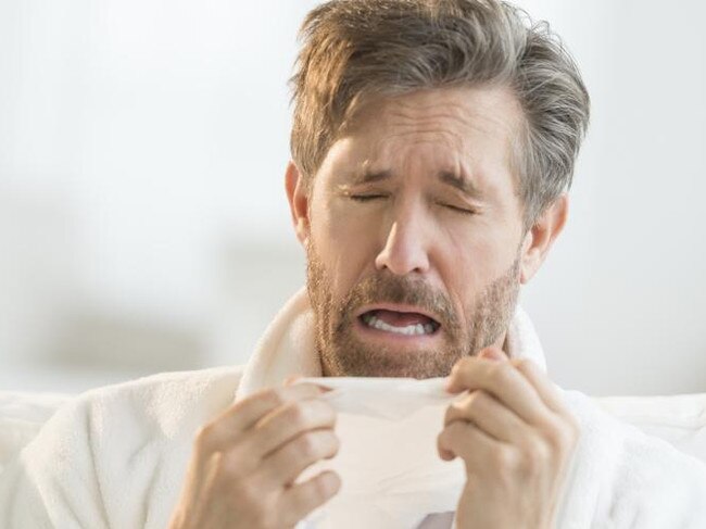 Man Sneezing Into Tissue