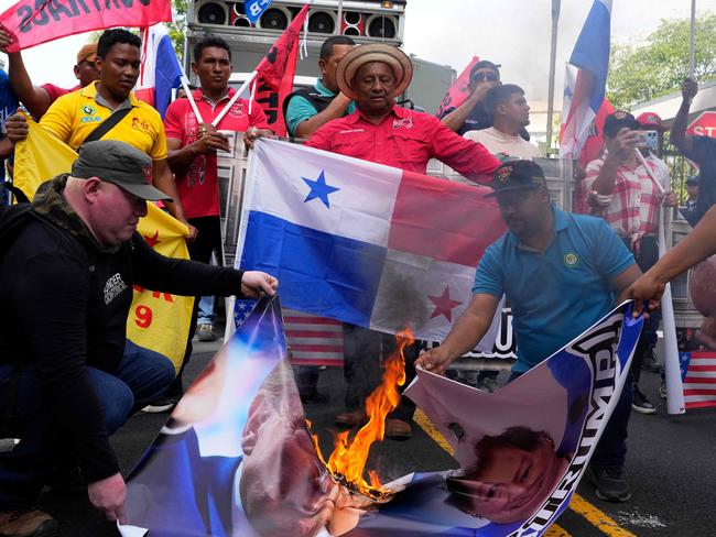 Demonstrators burn a banner with the image of US President-elect Donald Trump during a protest outside the US embassy in Panama City on December 24, 2024. Picture: AFP