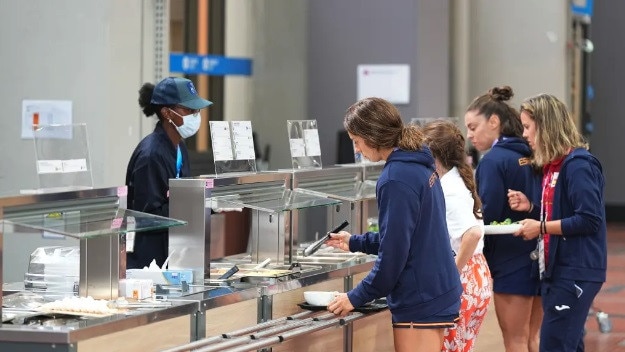 Athletes stand at the food counter in the Olympic Village. Picture: Michael Kappeler/picture alliance via Getty Images