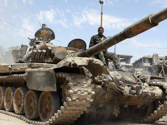 A picture taken on April 8, 2018, shows Syrian Army soldiers advancing in an area on the eastern outskirts of Douma, as they continue their fierce offensive to retake the last opposition holdout in Eastern Ghouta. The Syrian government unleashed a ferocious assault on the then-rebel stronghold of Eastern Ghouta on February 18, aiming to crush Islamist and jihadist groups on the doorstep of the capital. / AFP PHOTO / STRINGER