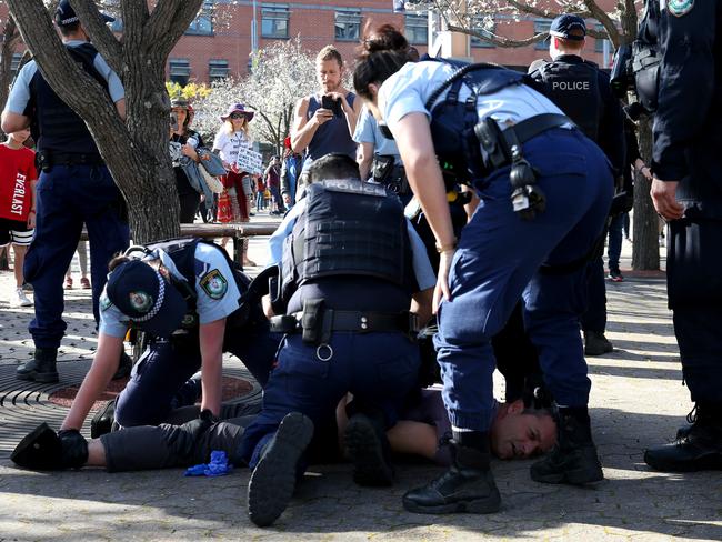 A man is pinned to the ground by police at a ‘Freedom Day’ protest in Sydney Olympic Park on September 5. Picture: Damian Shaw