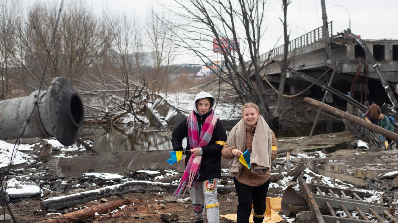 Women crosses the destroyed bridge across the Irpin river in Ukraine. Picture: Getty Images