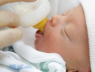 RendezView. Teeny, tiny newborn baby sucking on the teat of a bottle that had nourishing formula. But it wasn't breast milk so eyebrows were raised. (Pic: iStock)