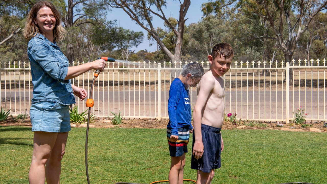 Quorn residents Annelise Perry sprays two of her sons. Picture: Peter Taylor