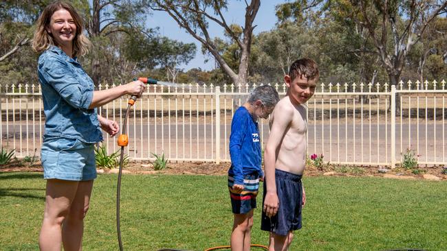 Quorn residents Annelise Perry sprays two of her sons. Picture: Peter Taylor