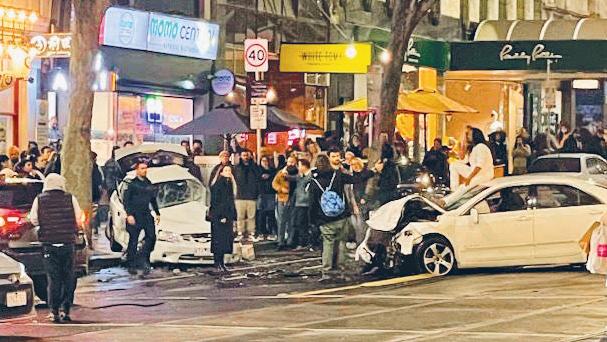 The driver surveys the carnage from the roof of his car following the crash in Melbourne’s Bourke Street on Friday night.