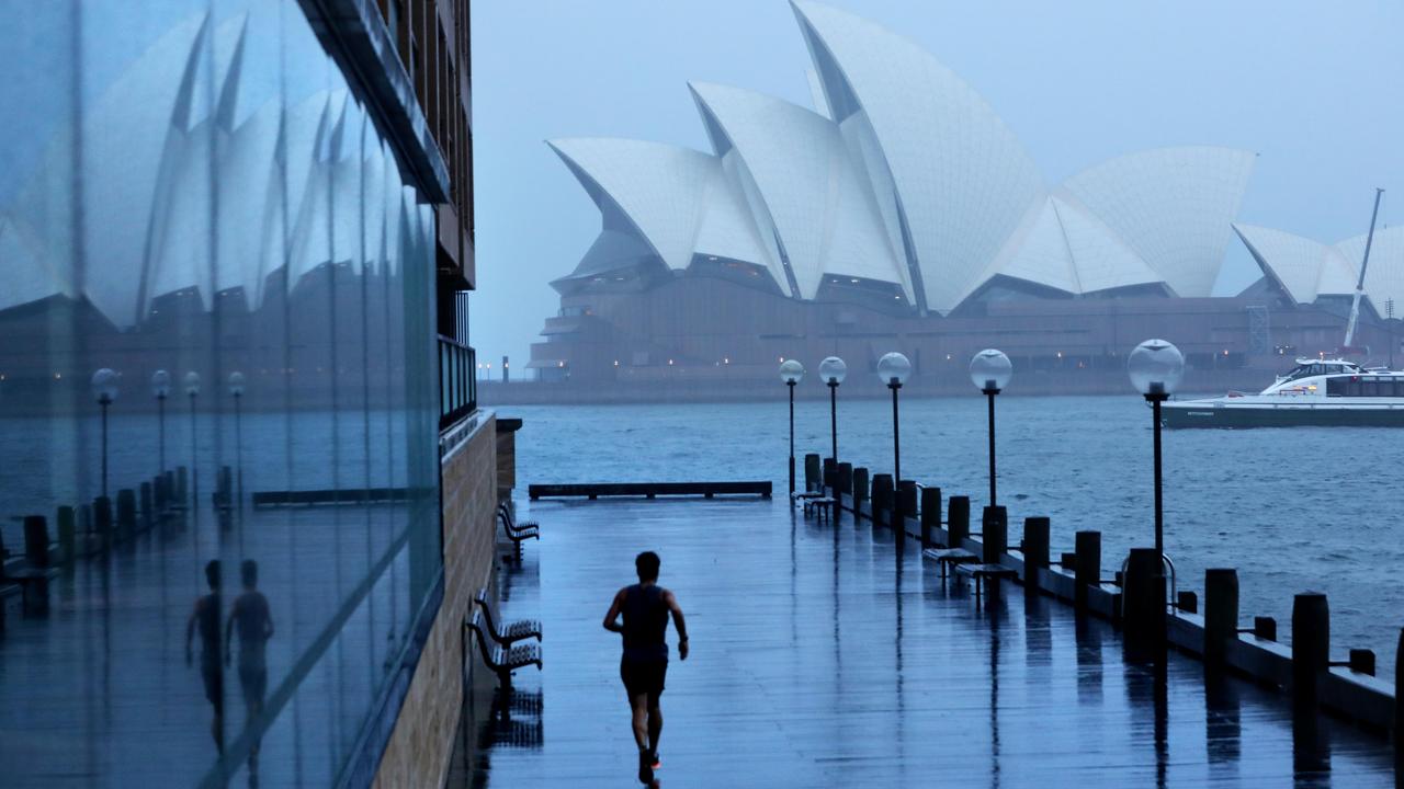 A man running in the rain near Sydney Opera House on Monday morning. Picture: NCA NewsWire / Damian Shaw