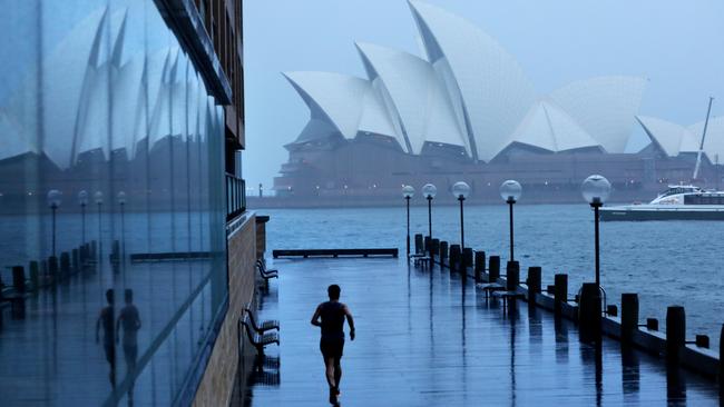 A man running in the rain near Sydney Opera House on Monday morning. Picture: NCA NewsWire / Damian Shaw