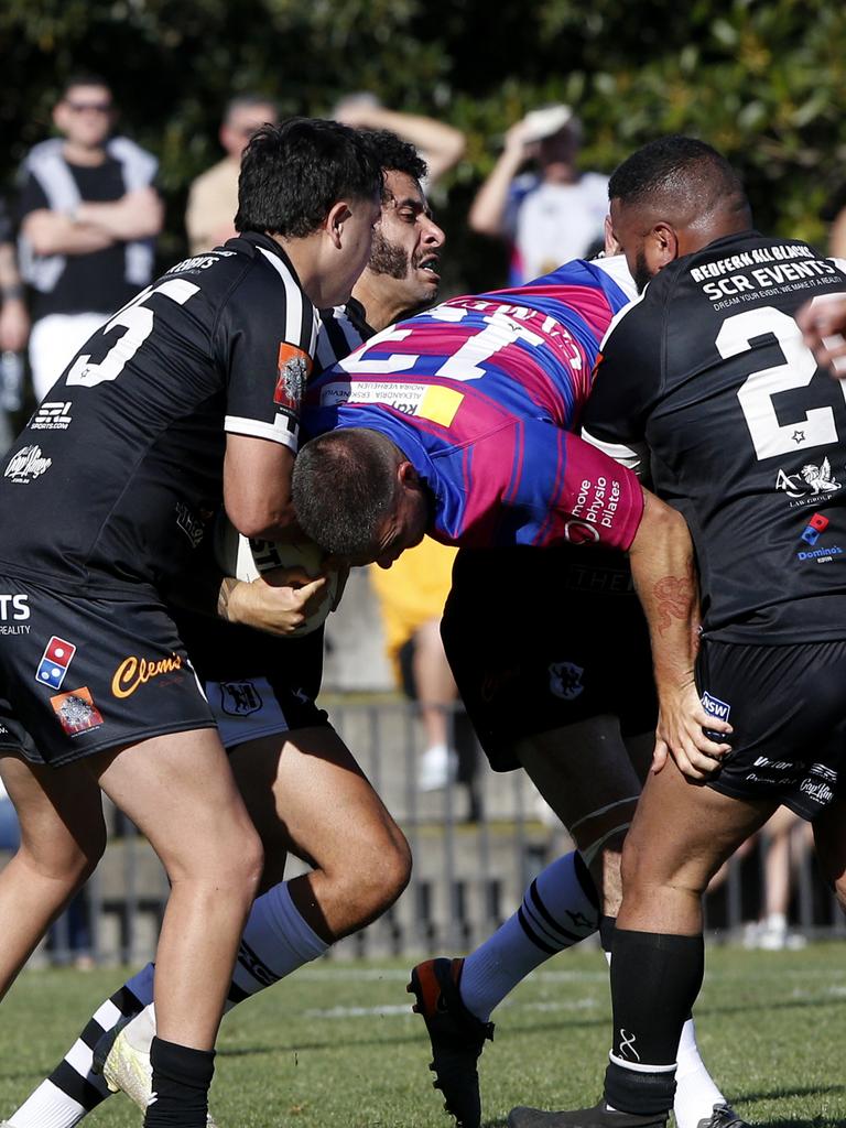 Alexandria Rovers' Denver Burns is raised off the ground in a tackle. Picture: John Appleyard