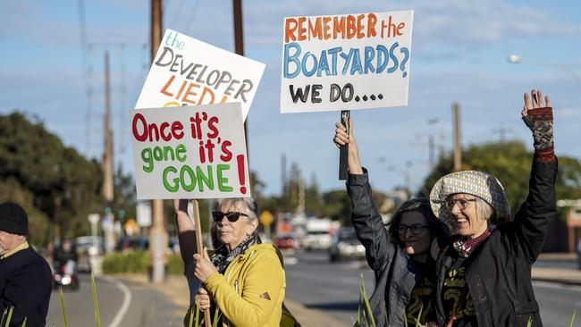 Protesters with signs at Shed 26. Photo: AAP/MIKE BURTON