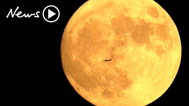 Striking video captures plane flying in front of full moon