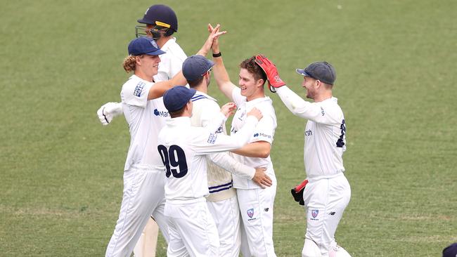 Hayden Kerr celebrates with his team after taking the wicket of Victorian Xavier Crone on day three of the Sheffield Shield match at the Sydney Cricket Ground.