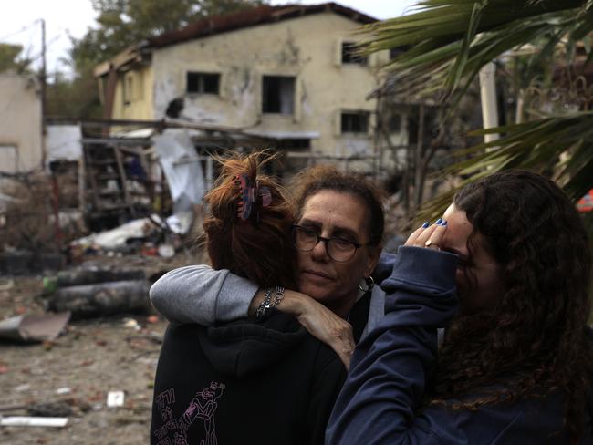 Residents embrace at the site of a rocket attack on November in Rinatya, Israel. Picture: Getty Images