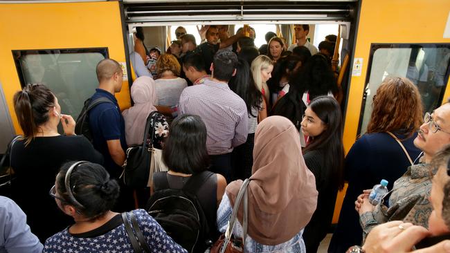 Commuters cram on to a packed carriage after waiting up to an hour for a train on Tuesday night at Central Railway Station. Picture: Jonathan Ng